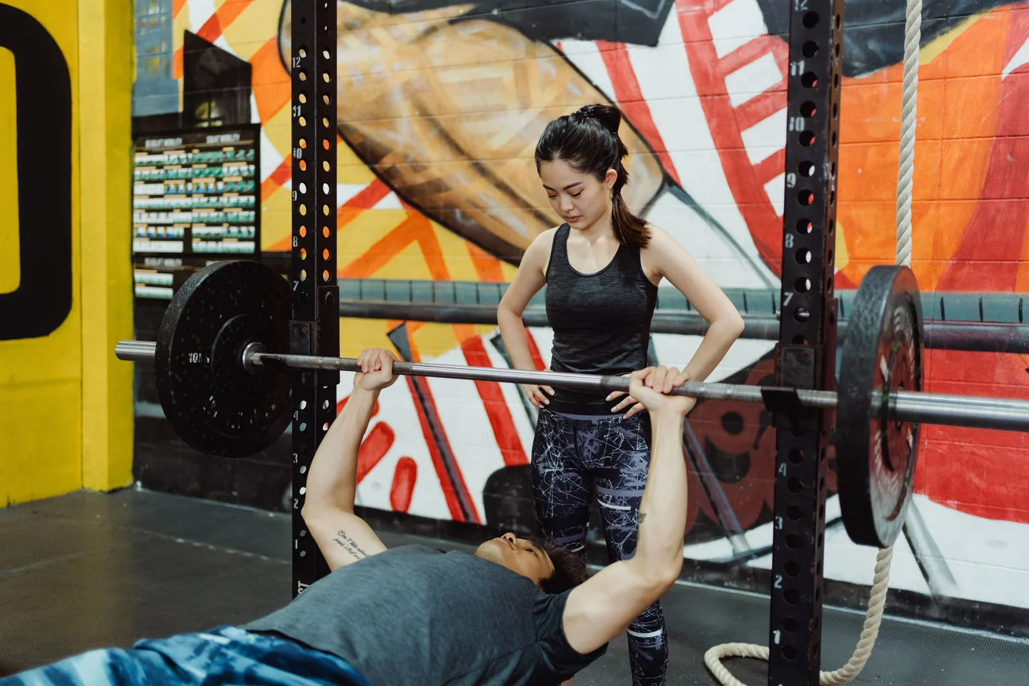 A lifter benching with a spotter standing behind the bar