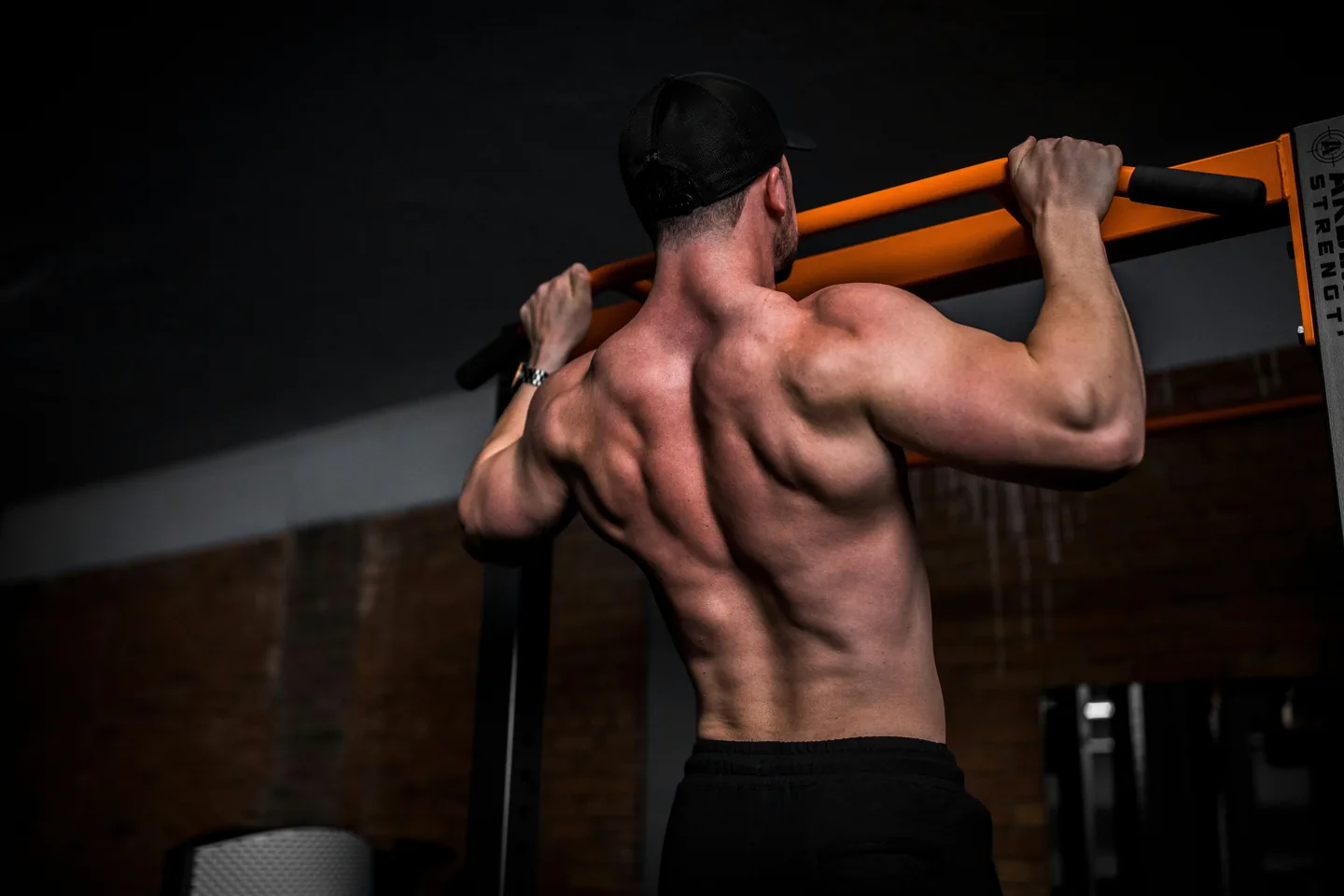 A lifter pulling up to a bar, seen from behind